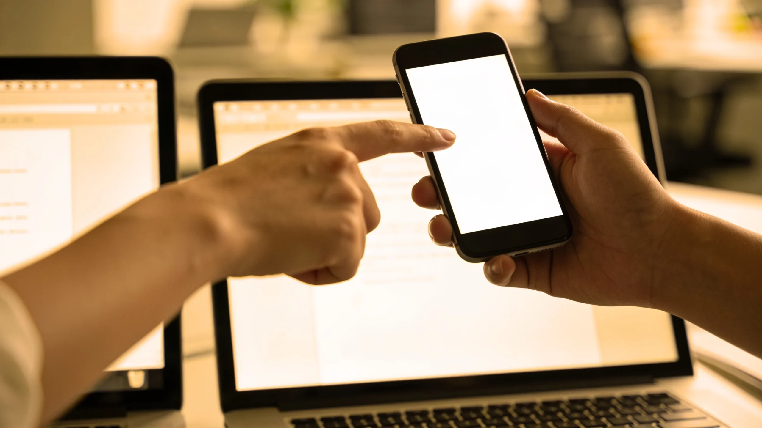 Persona compartiendo la pantalla del portatil con el movil para pedir ayuda a la IA