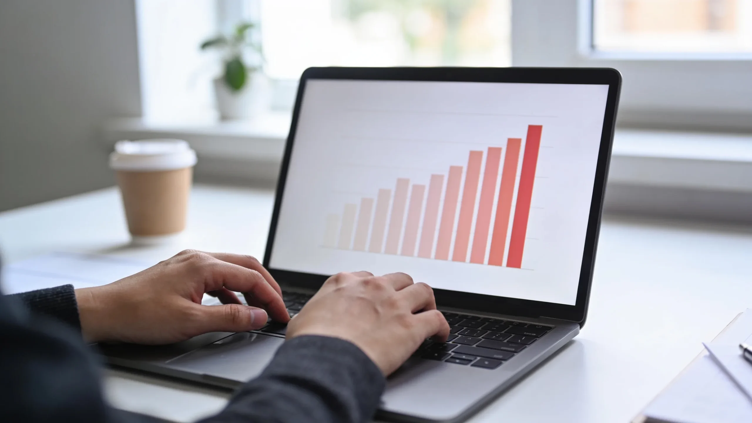 Persona usando Copilot en Excel en un portatil con un grafico de barras en pantalla