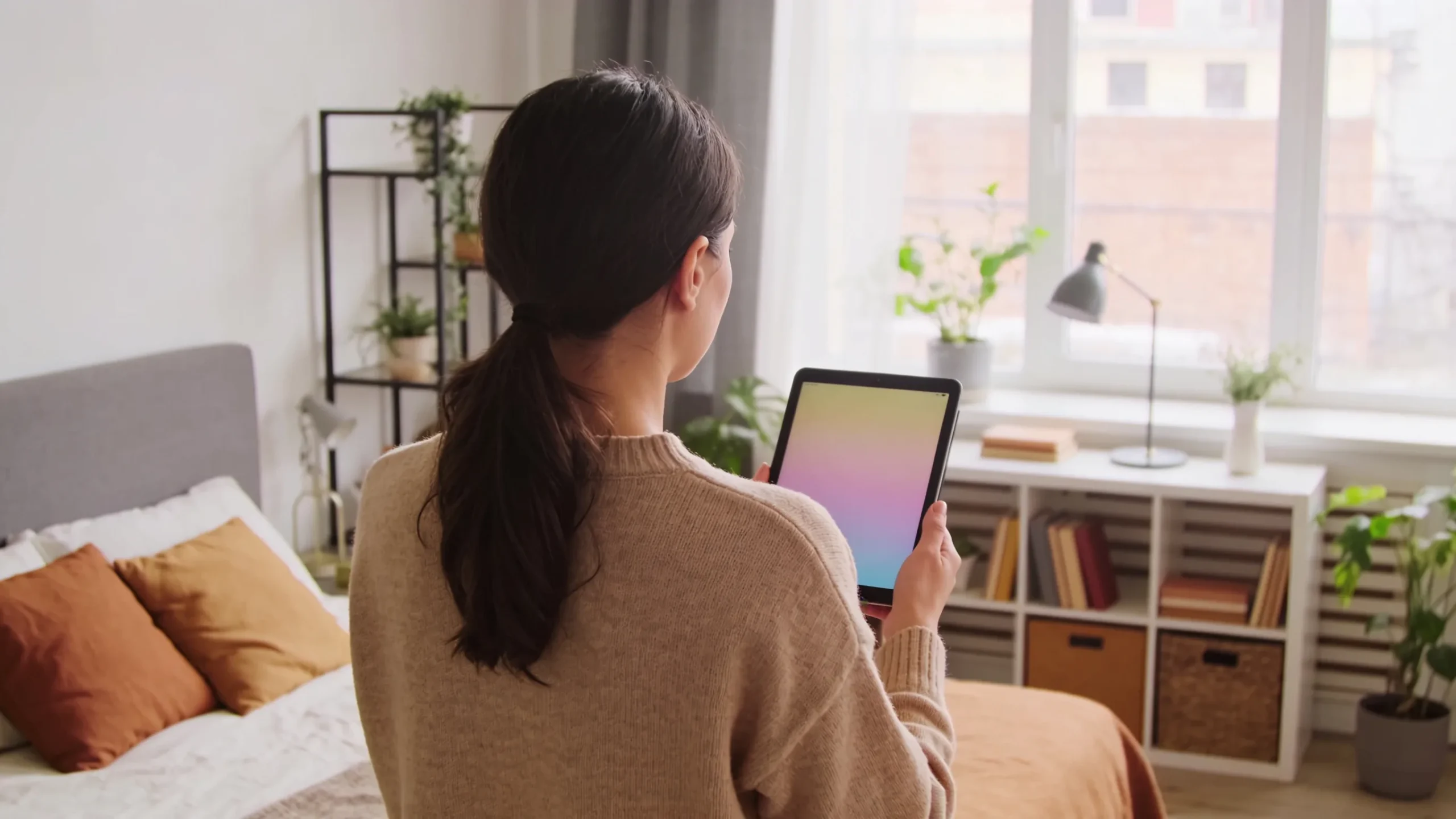 Mujer con una tablet decorando una habitacion moderna con ayuda de la IA