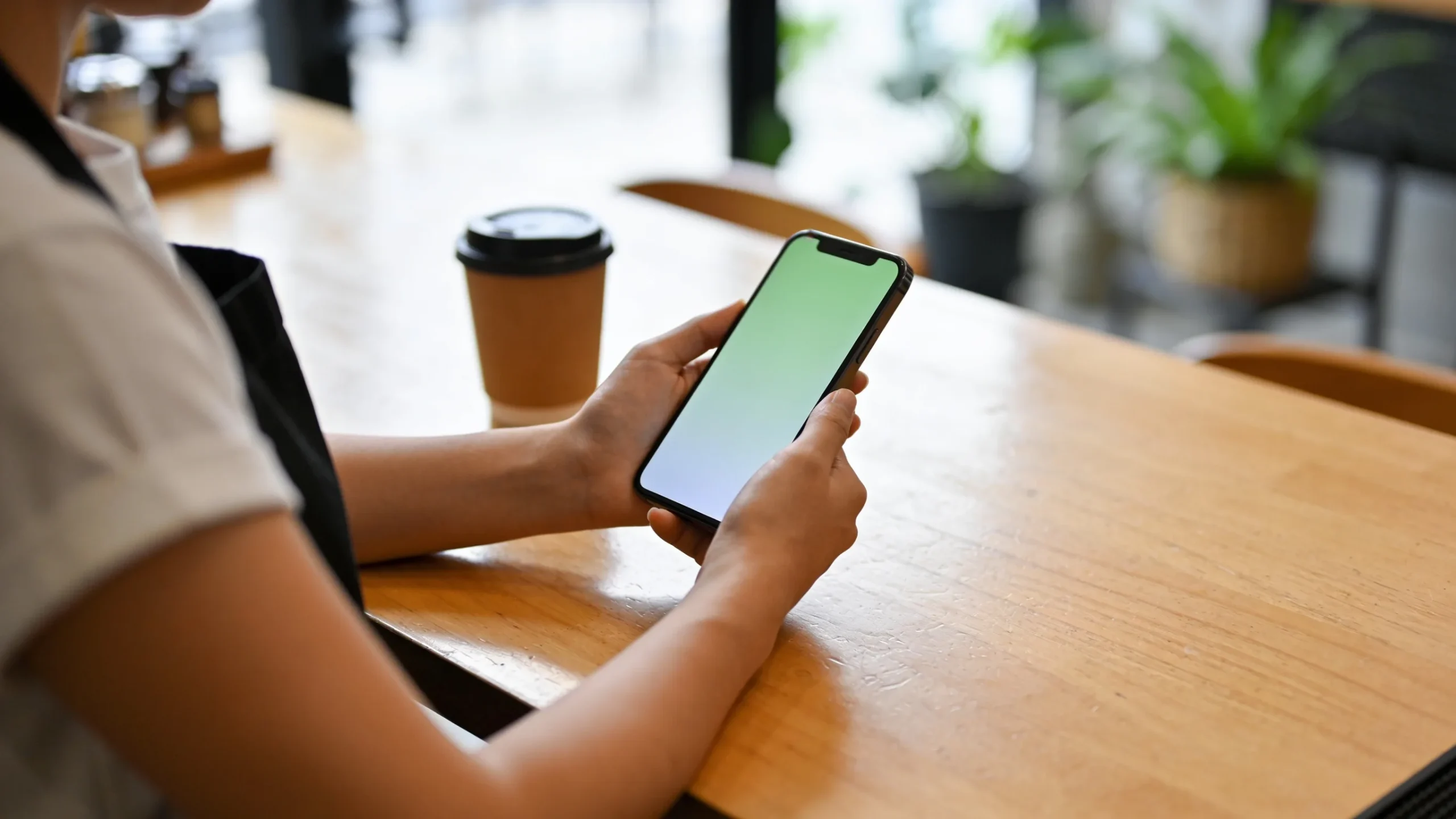 Duena de una cafeteria configurando mensajes automaticos de WhatsApp Business en su movil