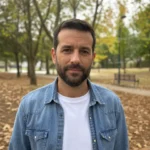 Foto de partida: retrato de medio cuerpo de un hombre con barba y camisa vaquera en un parque en otoño